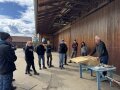 Personen stehen im Außenbereich eines Holzbaus