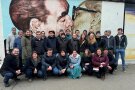 Die Studierenden stehen zum Gruppenfoto vor dem Gemälde "Bruderkuss".