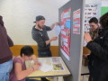 Studierende im Klassenzimmer vor Pinnwänden