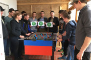 Mehrere Personen stehen um Tischkicker